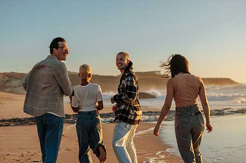 people in aftercare walk on the beach