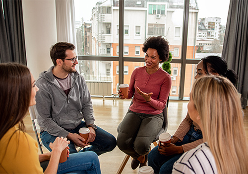 female addiction treatment specialist leading a group therapy session of men and women as part of a benzo detox program