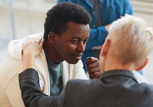 a man holding another man's shoulder