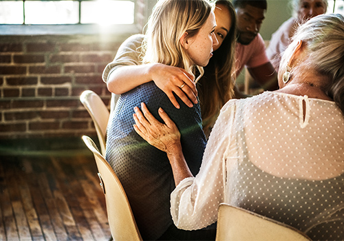 members of a heroin addiction treatment program supporting one another during group therapy