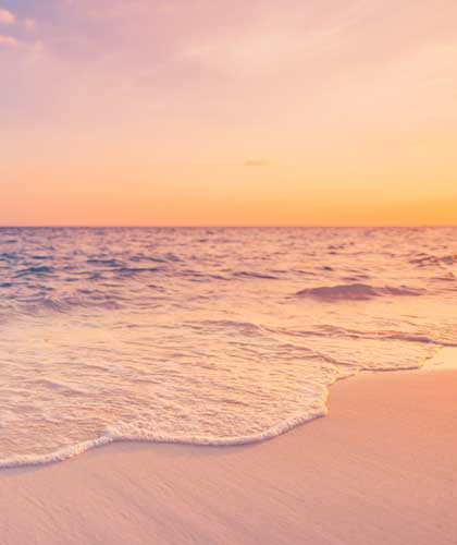 a beach with waves and a sunset