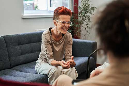 a woman sitting on a couch talking to a man